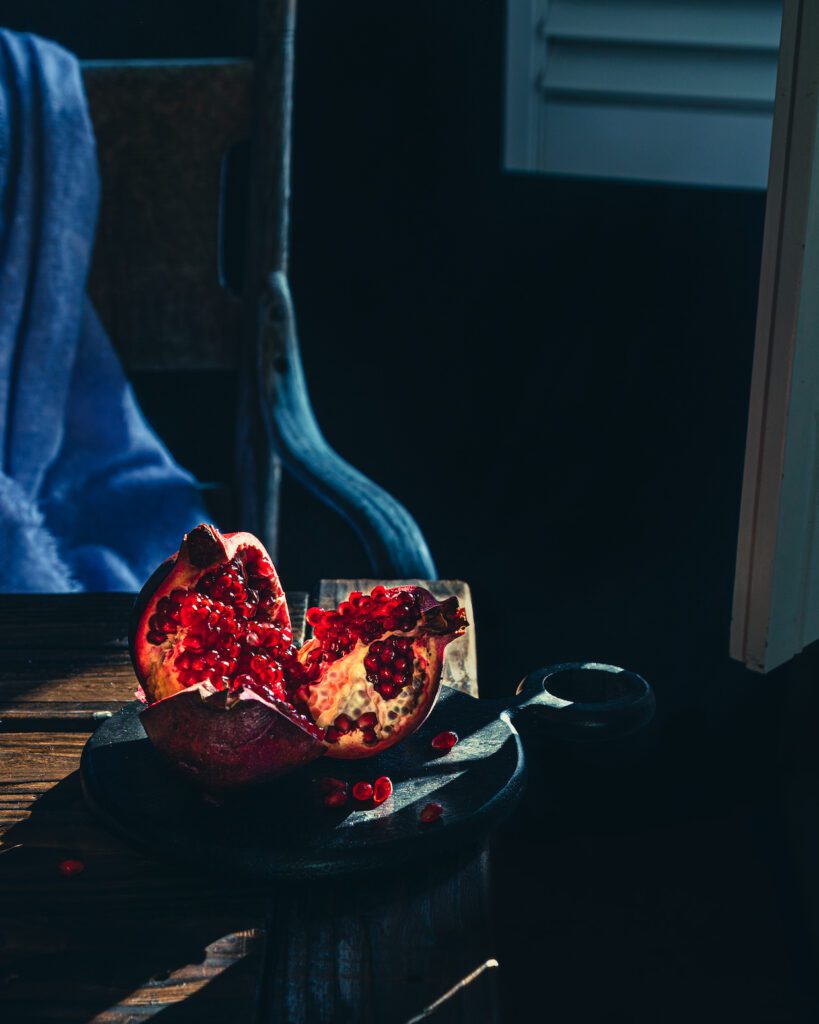 "Fruit Whisperer" is a photograph by Mina Afshari where she puts the spotlight of the sun on a pomegranate.