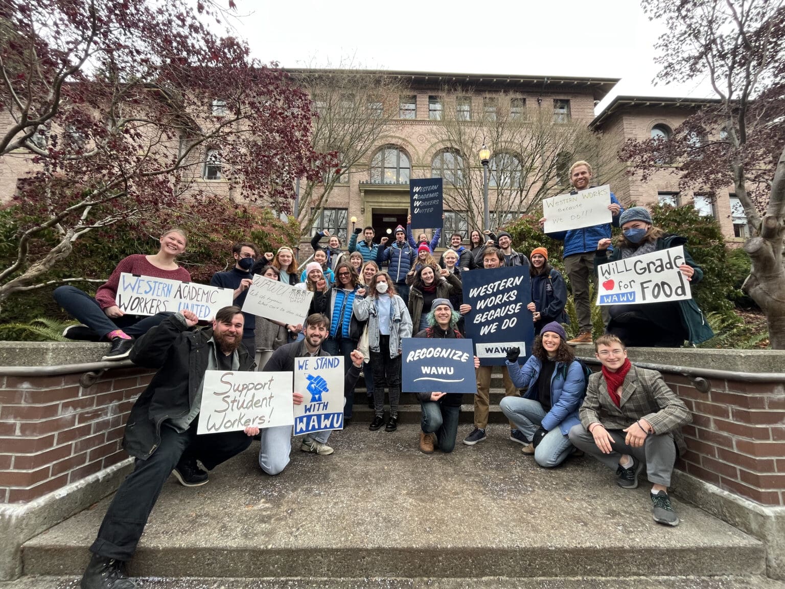 Academic Student Employees stand on the stairs of Old Main at Western Washington University in December 2022. The group of undergraduate and graduate student employees formed a union June 12.