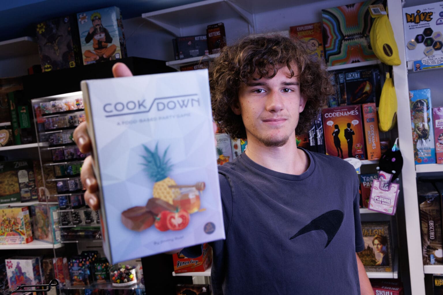 Jimmy Rust holding up his board game called 'Cookdown'.