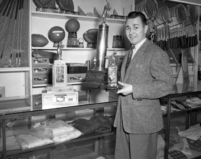 Longtime Bellingham Bells Manager Joe Martin poses with national and state National Baseball Congress League trophies in 1947. Martin led the Bells to 20 Washington state championships and two third-place national finishes from 1942–73.