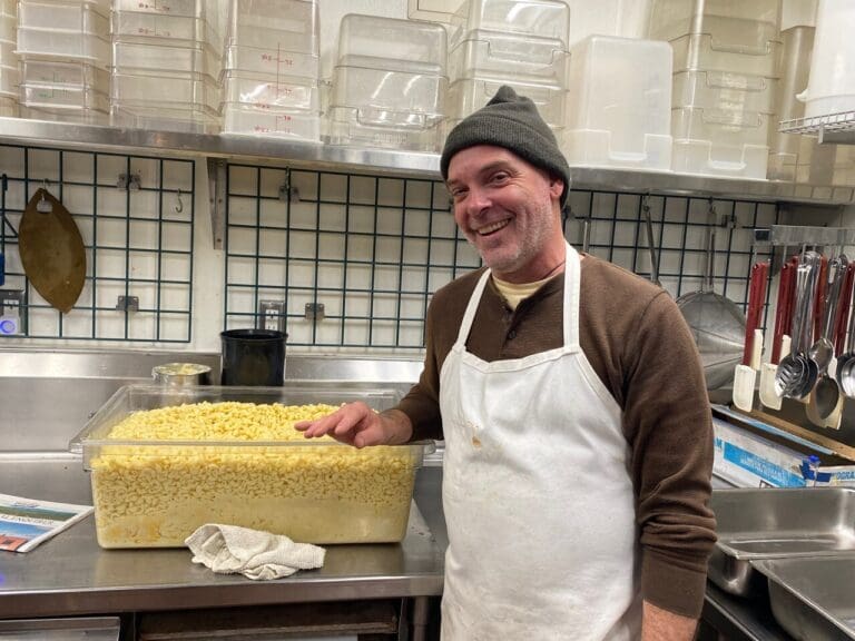 Charles Claassen poses for a photo with a giant tub of mac and cheese. Claassen was a fan of inventive cooking