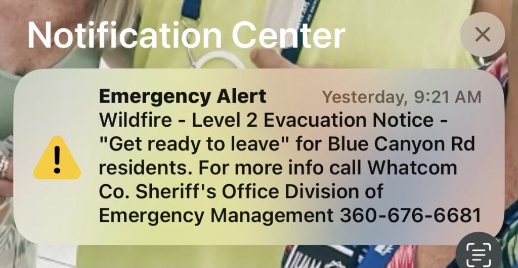 A message notification alerting the phone user of a Wildfire alert and an evacuation notice.