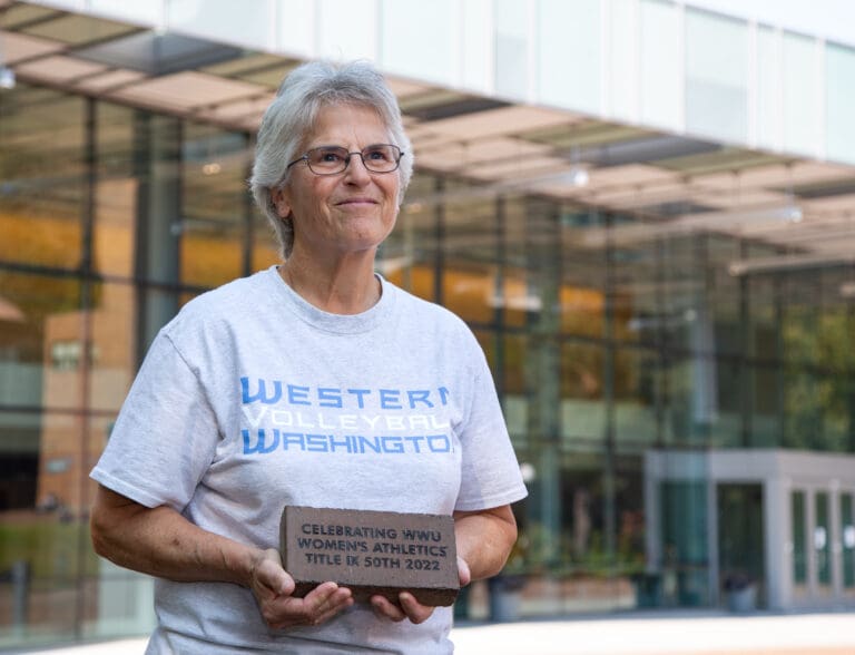 Terri McMahan holds a brick honoring Title IX outside of Carver Gym at Western Washington University on Sept. 26. McMahan played on Western's volleyball team in the 1970s.