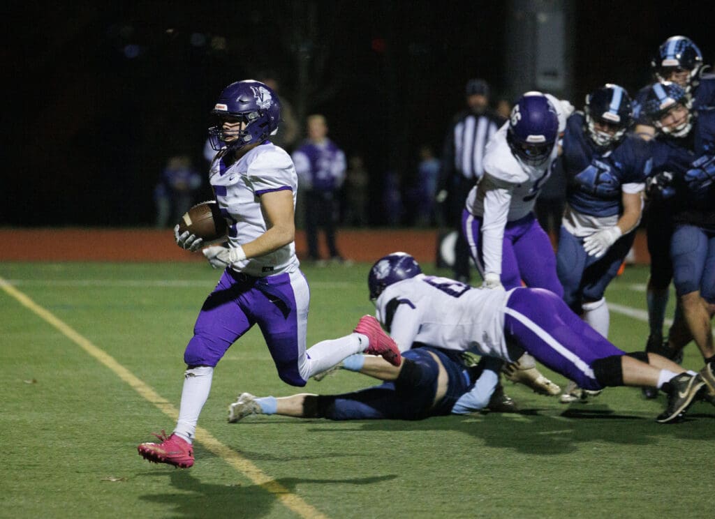 Nooksack Valley’s Skyler Whittern runs for a touchdown leaving behind both team's players who are caught trying to block one another.