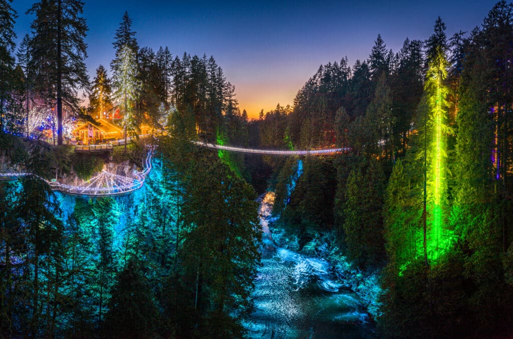 The Canyon Lights festivities at Capilano Suspension Bridge Park light up trees, water, and cabins.