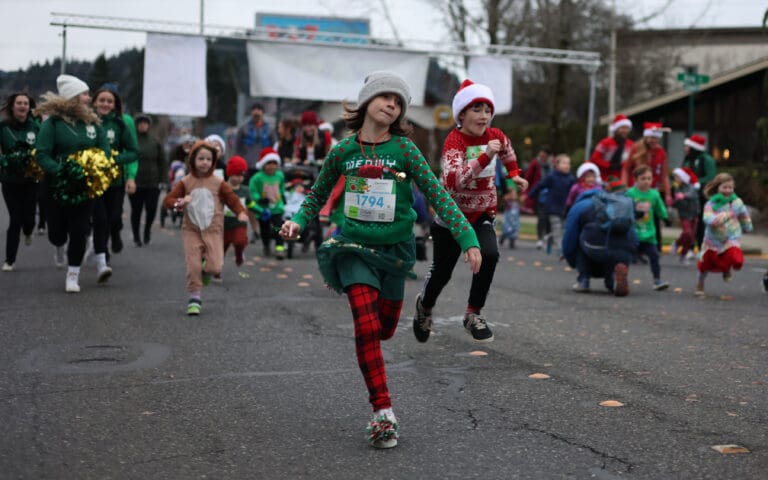 Olive Erdmann takes the lead in the Kids Fun Run with the Elves.