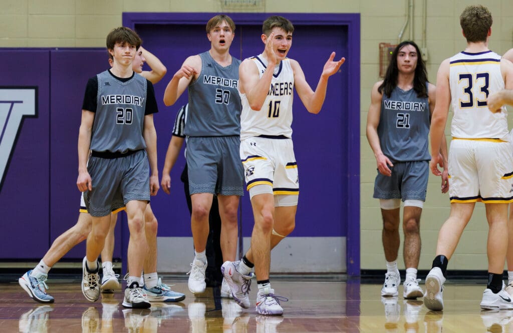 Nooksack Valley's Caden Heutink celebrates by clapping as other players react around him.