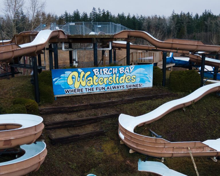 A gap is visible in the wall of the slide beneath the Birch Bay Waterslides sign that reads out : Birch Bay Waterslides, Where The Fun Always Shines!