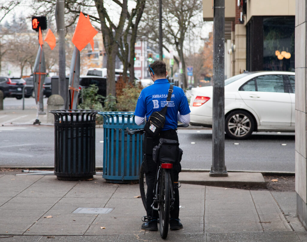 A Downtown Ambassador stops on a bike outside of Little Cheerful Cafe on Nov. 15, 2023.
