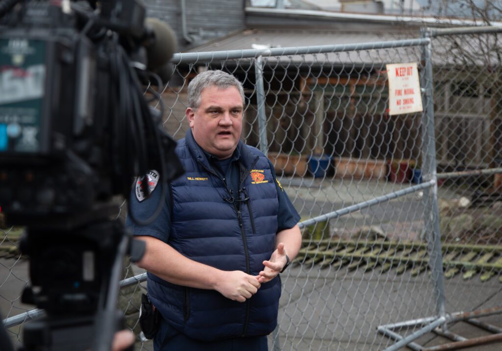 Bellingham Fire Chief speaks to TV cameras right in front of the fenced off areas outside the Terminal Building.