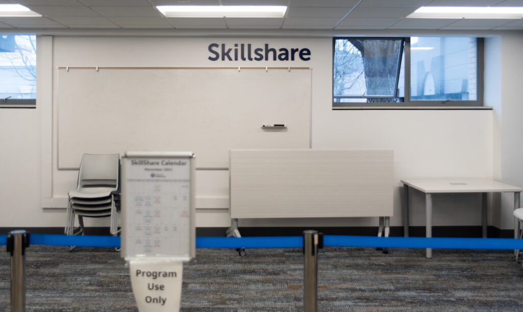 The white walls of the library has the words "Skillshare" written on the top.