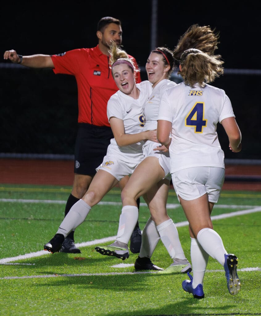 Ferndale’s Audrey Holdridge and sister Emily hug in celebration as another player runs up to celebrate with them.