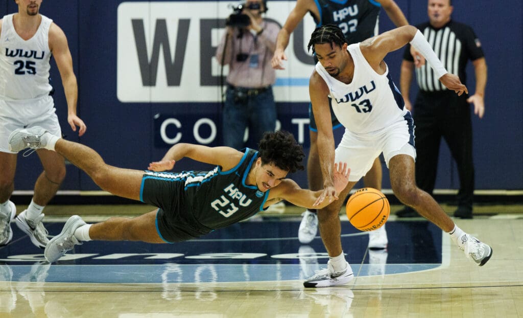 Western's Jonathan Ned gets a steal as Hawaii Pacific's Josh Nuisulu dives for the ball from the side but falls to the floor as other players rush to help.