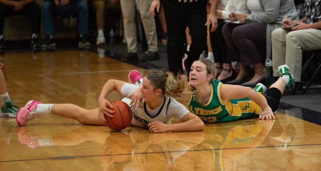 Nooksack Valley senior guard Devin Coppinger and Lynden freshman guard Finley Parcher battle for a loose ball.