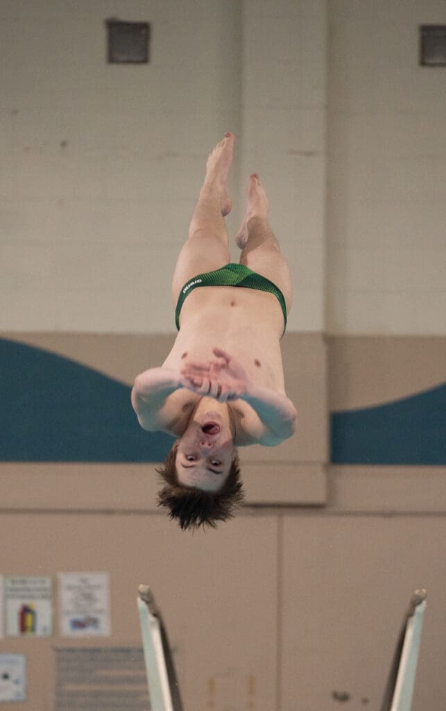 Sehome's Kaden Schmidt dives into the pool, upside down mid-air.