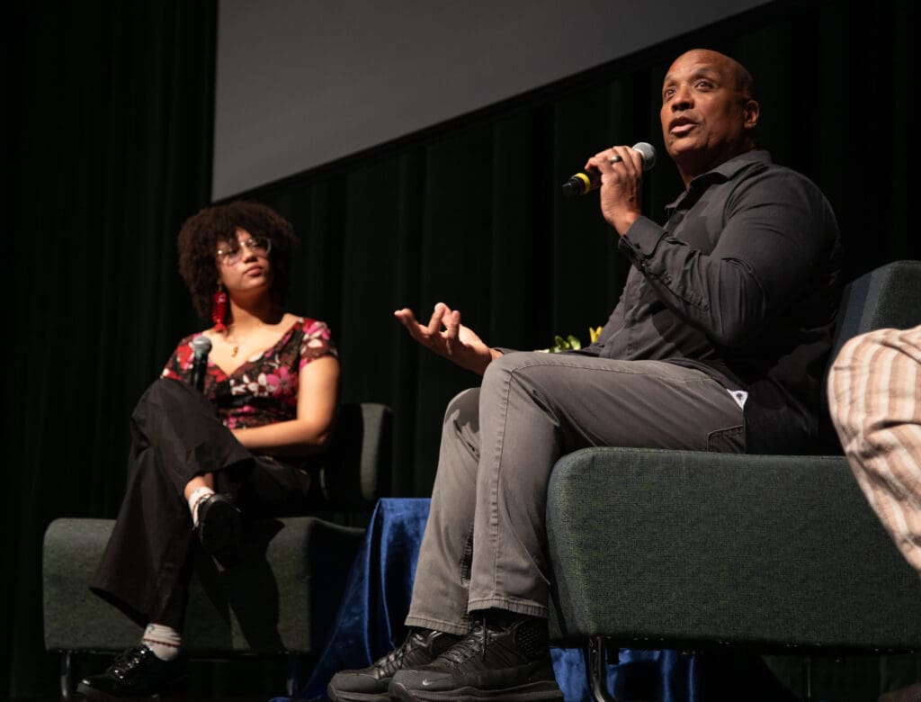 Keynote speakers Isabella McFrazier, left, and Brian Young share their experiences being Black in Bellingham while sitting on dark green sofas.