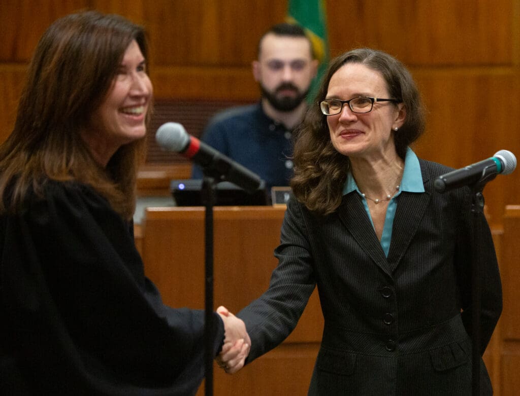 City council member Hannah Stone shakes hands with Judge Debra Lev after being sworn in for another term. Stone has served since 2018.