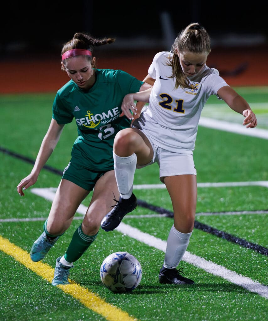 Sehome’s Madison Goodman and Ferndale’s Audrey Kallin battle for the ball along the sideline as their hands entangle during the scuffle.
