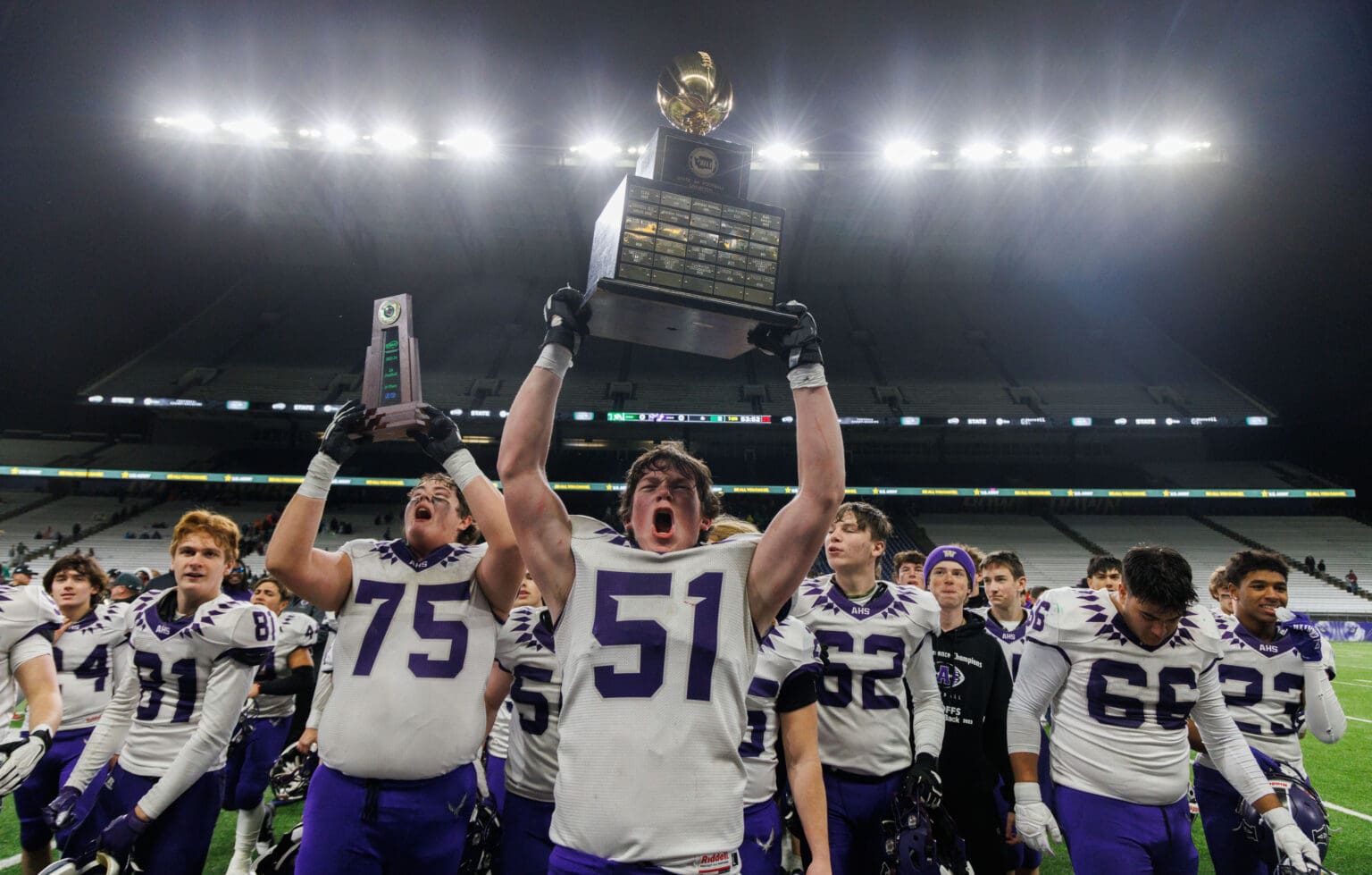 Anacortes celebrates winning its first-ever state title by raising the trophies above them.