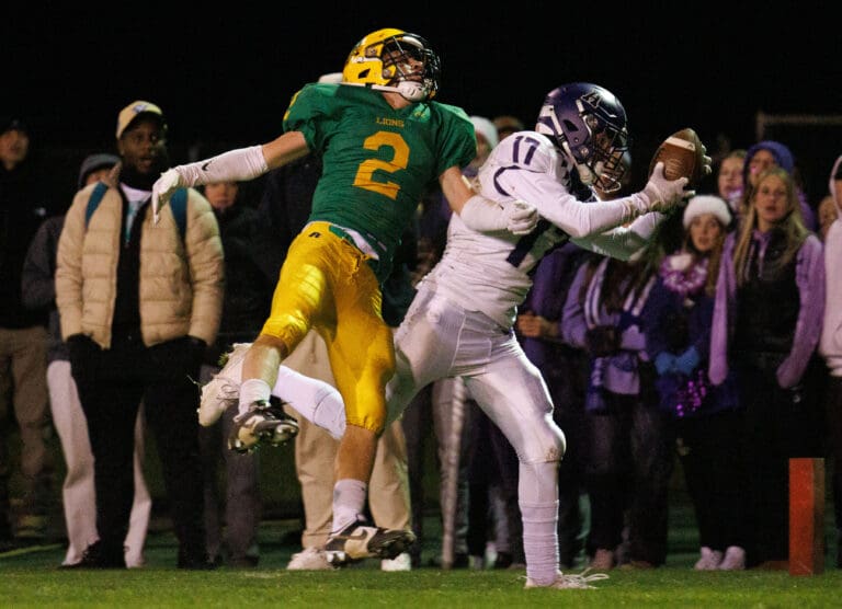 Anacortes' Luca Moore intercepts a pass as Brady Elsner falls backward from the interception.