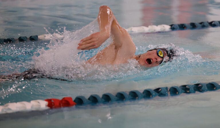 Bellingham’s Micah Flint breaches for air sideways as they lift up their arm mid-swim.