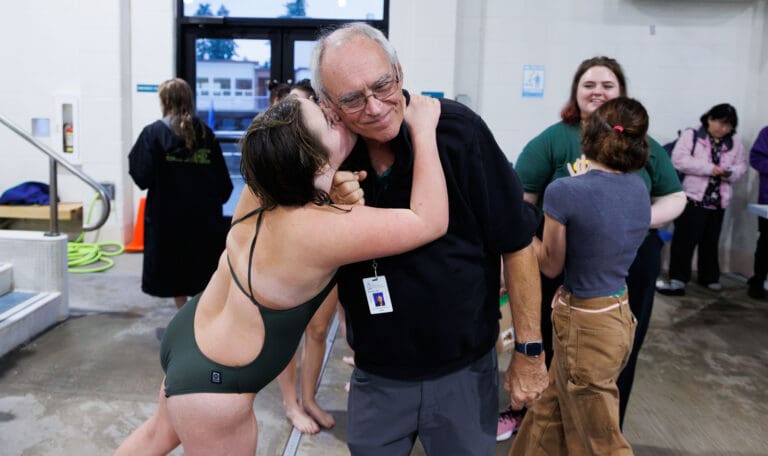 Sehome swim coach Don Helling gets a kiss on the cheek from daughter Lauren Gongwer Oct. 17 after beating Squalicum in a dual meet at the Arne Hanna Aquatic Center. Helling will retire from coaching after the fall season following a 49-year high school coaching career — 38 of which were at Sehome.