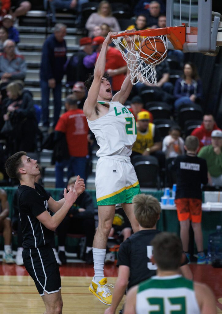 Lynden’s Anthony Canales dunks the ball, leaving two defenders below to watch.