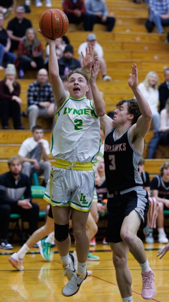 Lynden’s Brady Elsner runs the baseline for the basket as a defender tries to reach to block.