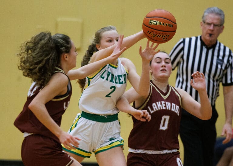 Lynden’s Kalanie Newcomb steals the ball from two Lakewood players along the sideline Dec. 8