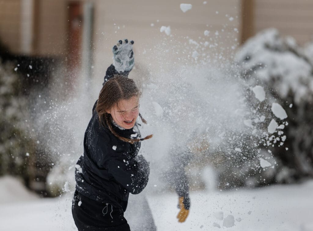 Mikaela DiStefano gets hits in the head thrown by Claire Logan as they snowball fight in Bellingham.