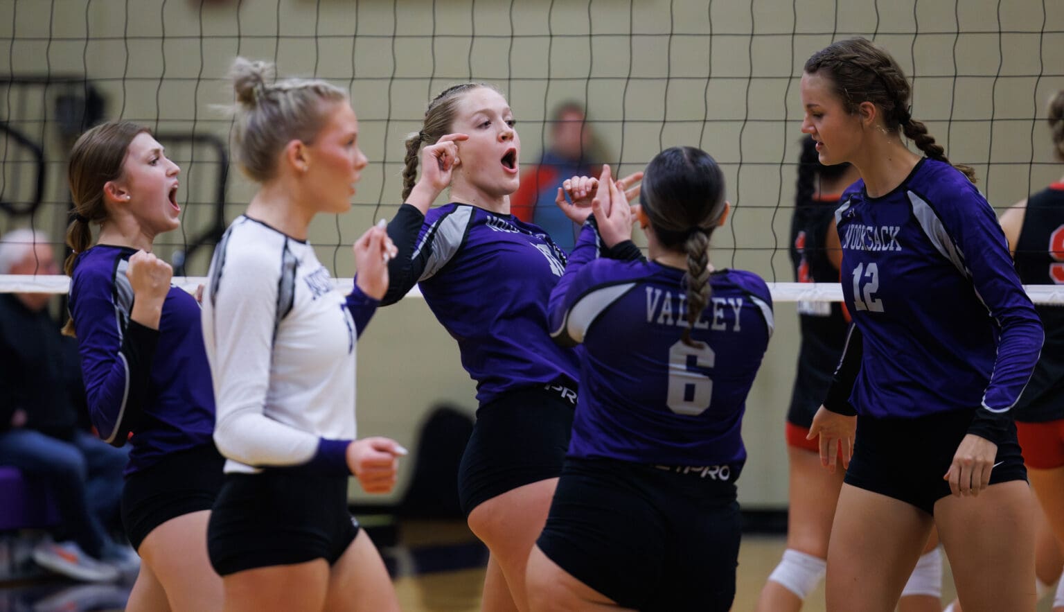 Nooksack Valley’s Lainey Kimball, center, celebrates with teammates in a close huddle after scoring a point.