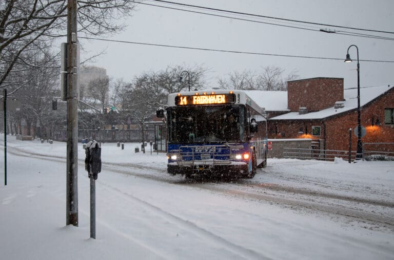 A WTA bus leaves Bellingham Station as it tries to maneuver onto the icy snow as snow falls.