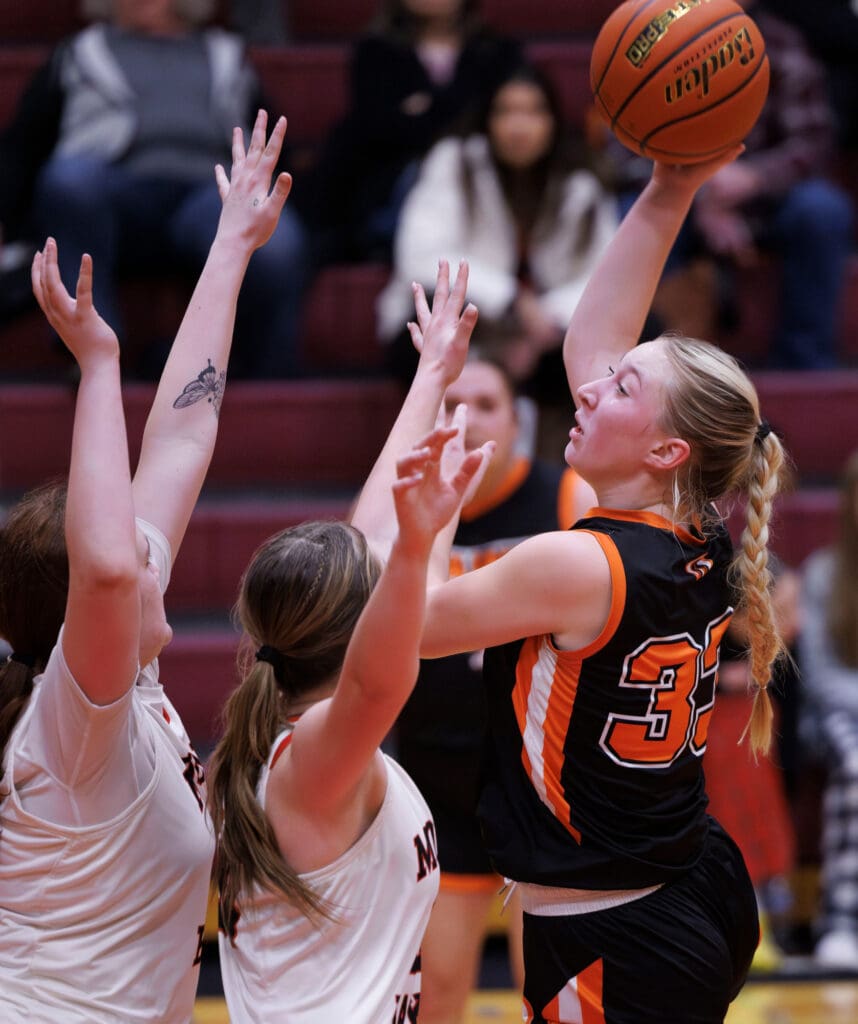 Blaine’s Deja Dube floats a shot over two Mount Baker defenders as they reach out for the ball as spectators watch from the bleachers.