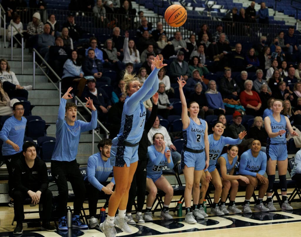 Western Washington University's Riley Dykstra sinks a 3-pointer as her teammates get excited in anticipation of the shot.