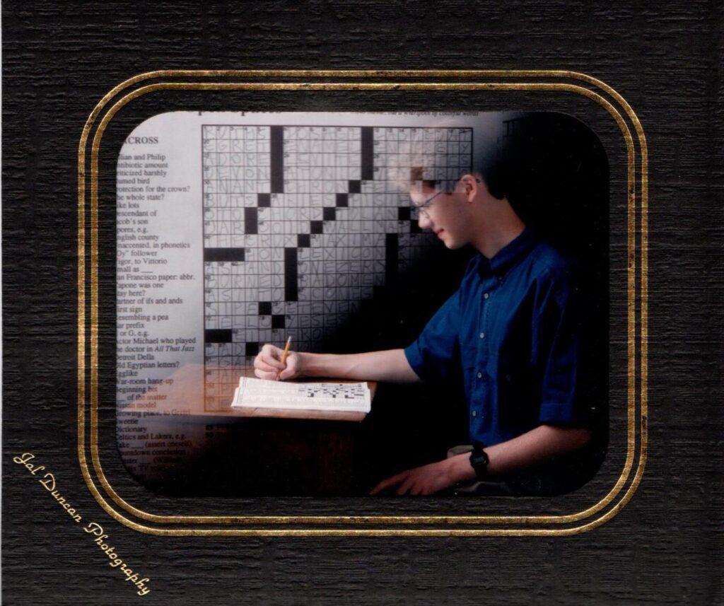Matt Jones completes a crossword puzzle for a photoshoot when he was younger with a crossword graphic.