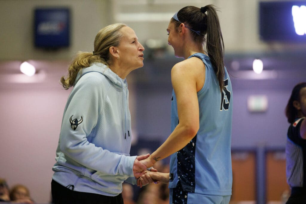 Western Washington University head coach Carmen Dolfo smiles as she greets Brooke Walling heading for the bench near the end of the game as they hold hands.