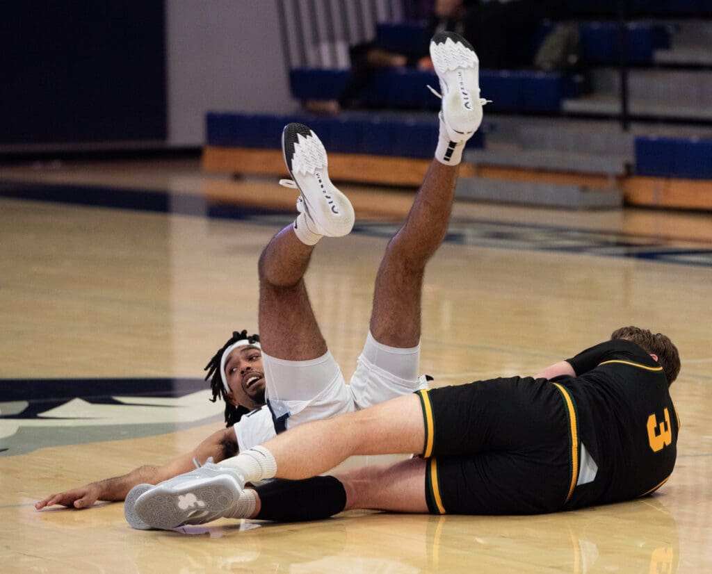 Western senior forward Jonathan Ned lays on the floor after colliding with a defender.
