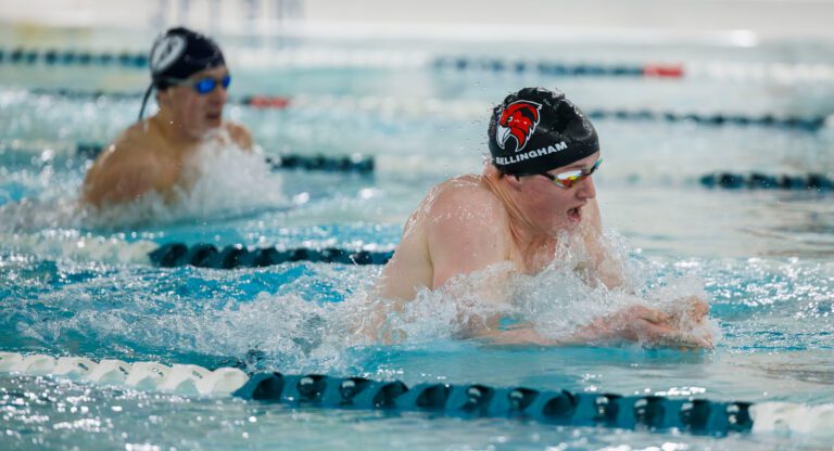 Bellingham’s Miles Cratsenberg keeps the lead against Squalicum’s Dylan Fisk in the 100-yard breaststroke as they both surface for air.