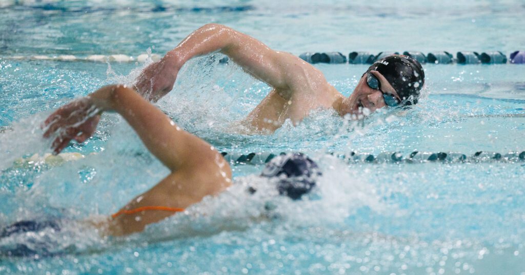 Bellingham’s Miles Cratsenberg and Squalicum’s Dylan Fisk swim in tandem as one of them breaches the water for air.