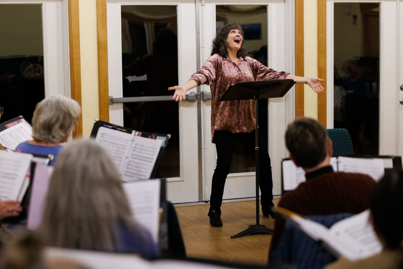 Artistic Director Wendy Bloom smiles enthusiastically as she directs singers with the Vox Pacifica choir during practice on Nov. 16 in Bellingham. The choir will perform its seasonal offering