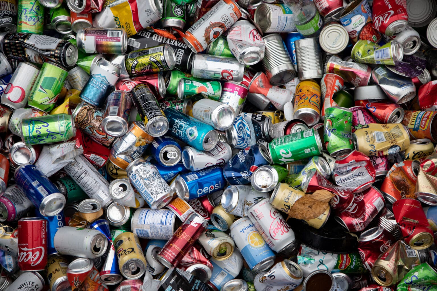 A photo of empty soda cans are piled high.
