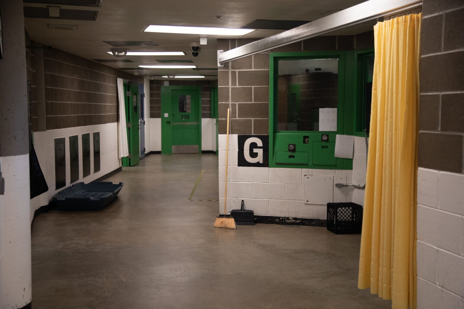 The hallway of the Whatcom County Jail in November that have green doors leading to inmate cells.