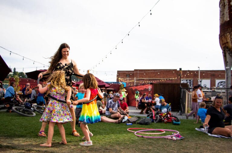 Stephanie Short teaches Emmeline and Sonny how to hula-hoop at Trackside Beer Garden during the Northwest Tune-Up Festival on July 16