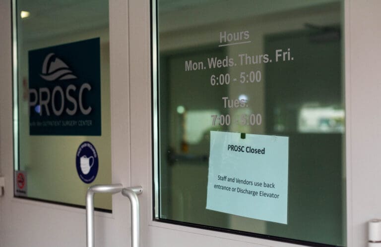 A closed sign is posted on the door of the former location of the Pacific Rim Outpatient Surgery Center that lets visitors know of their closure.