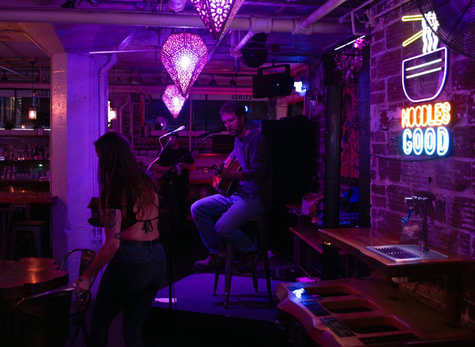 Pete Ruble performs at Culture Cafe where the interior is doused in purple lighting.