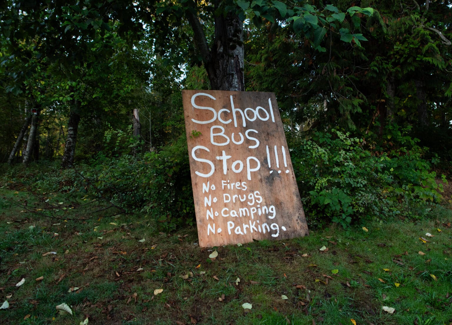 A handmade sign is propped up on a tree just outside an entrance to a homeless encampment near Walmart on Sept. 29.