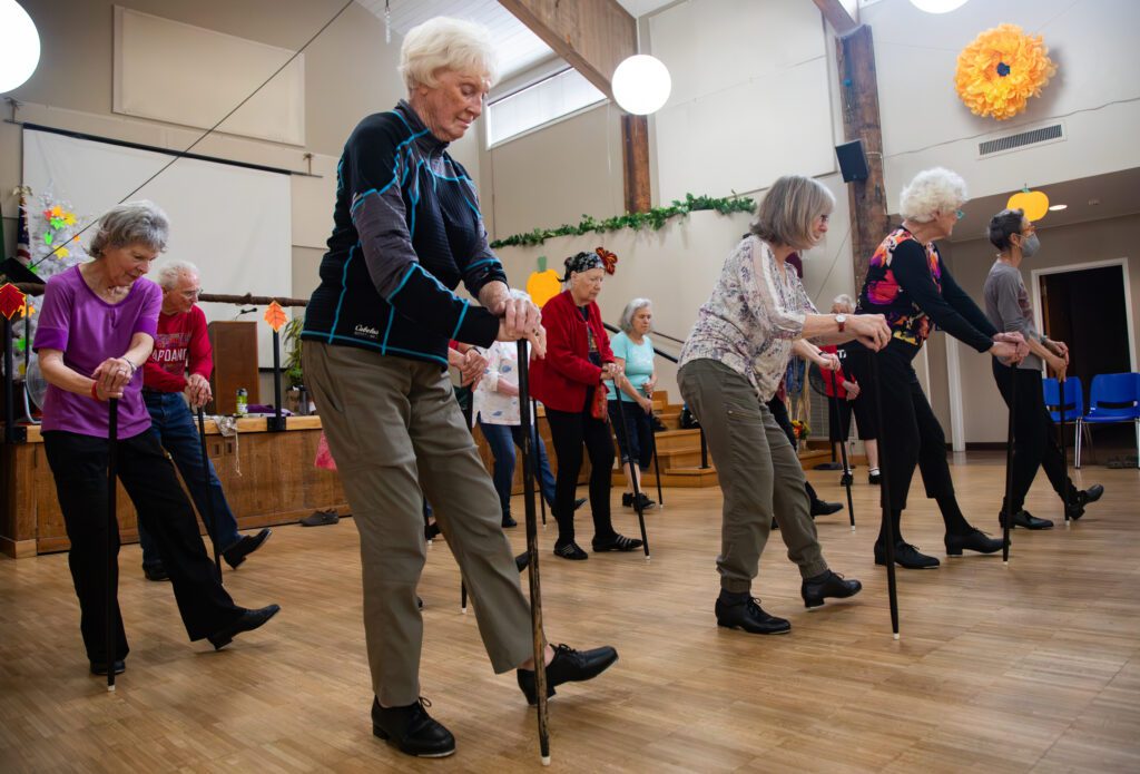 The Senior Steppers rehearse "Singin' in the Rain" as they tap dance with the help of a black cane.