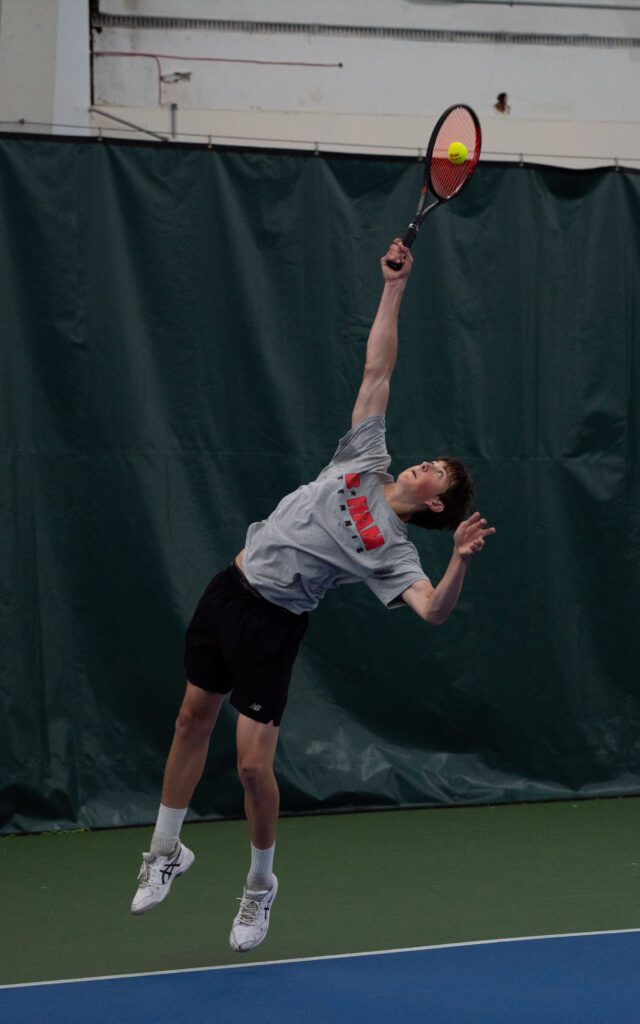 Bellingham's Nate Lyon leaps slightly off the floor to reach the tennis ball.