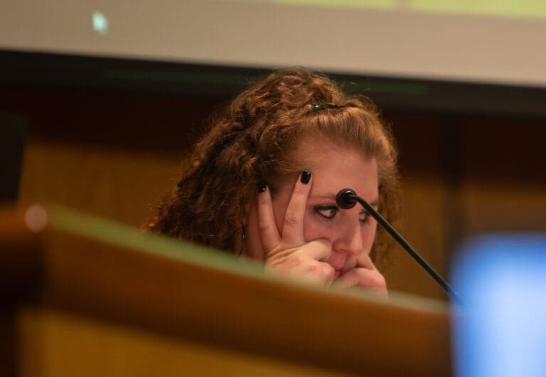 Whatcom County Council member Kaylee Galloway holds her head in her hands while listening to a public comment.