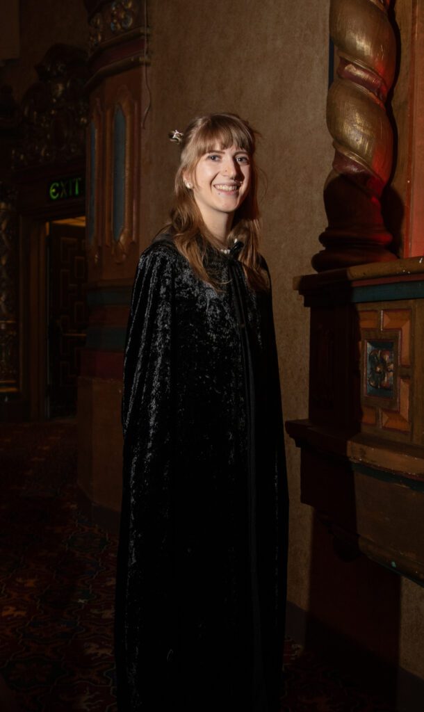 Heather Duncan smiles for the camera while wearing a large black robe.